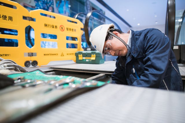 KONE technician repairing an escalator