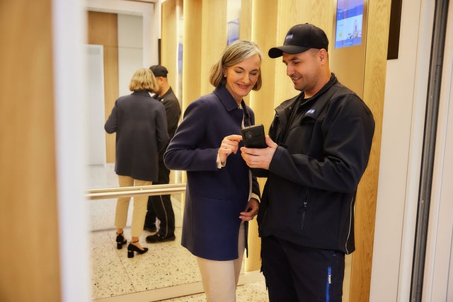KONE technician showing data to a lady