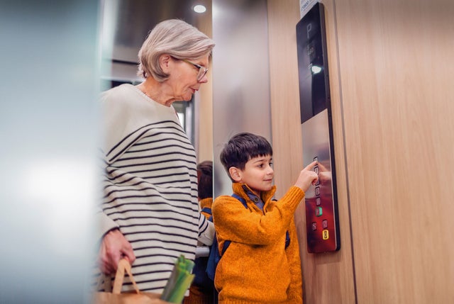 grandmother and child in elevator pressing the button