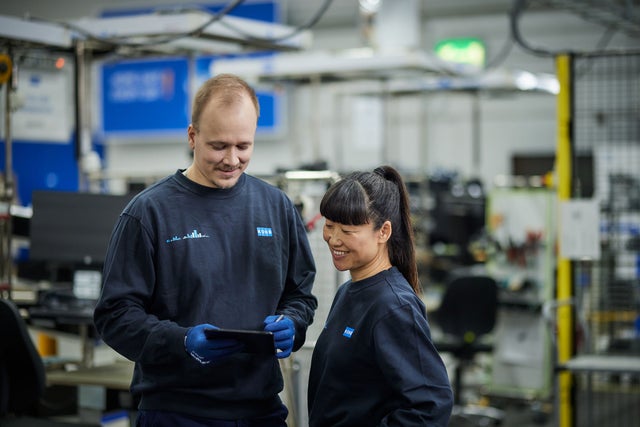 Two employees looking at a tablet in a factory environment